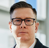 Portretfoto van Alexander Hughes, CEO en directielid van een cryptohandelsbedrijf